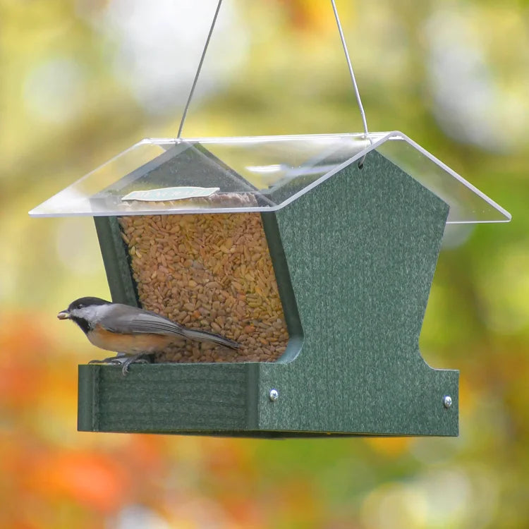 Duncraft Heritage Hopper Feeder, Green, with a chickadee perched on its trough. Features clearview panels and metal mesh flooring, stocked with seed.
