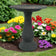 Sand Fiber Clay Bird Bath in a garden, featuring a full-sized basin for birds to play and splash. Lightweight and easy to move.