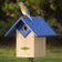 Duncraft Chalet Bluebird House & Pole: Bluebird perched on blue birdhouse with predator guard, overhanging roof, and ventilation, mounted on a 72-inch pole.