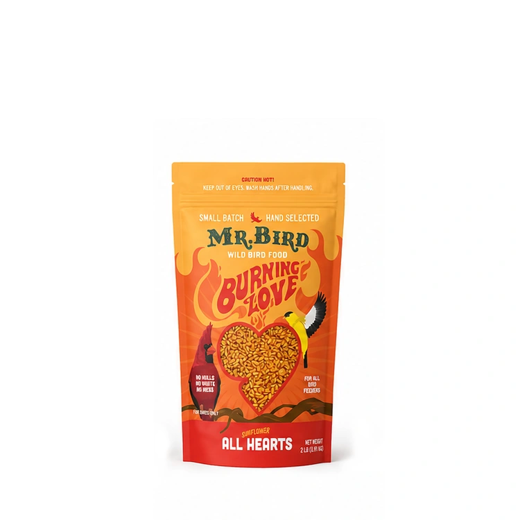 A stand-up pouch of Mr. Bird Wild Bird Food 'Burning Love' hand-selected for small birds, featuring a bright orange and red design with a heart-shaped window showing the birdseed inside.